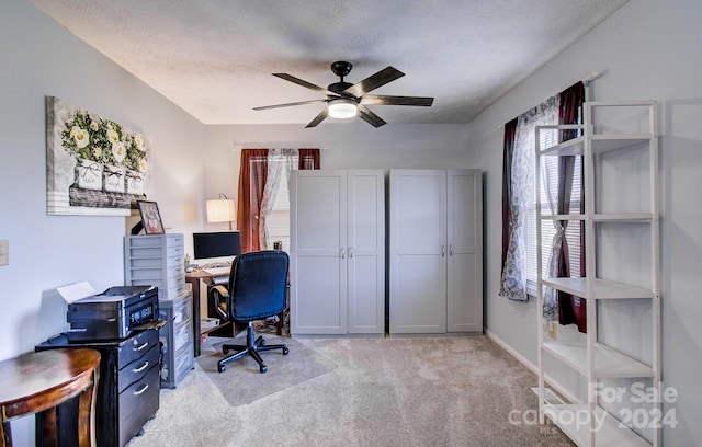 office space with ceiling fan, light colored carpet, and a textured ceiling