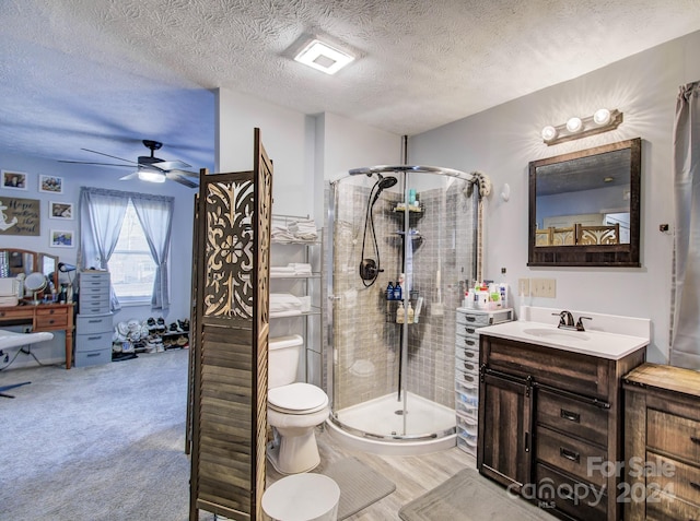 bathroom featuring ceiling fan, walk in shower, a textured ceiling, vanity, and hardwood / wood-style flooring