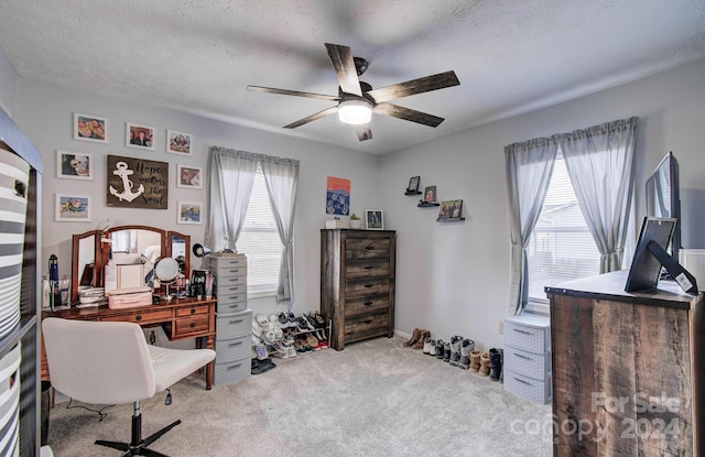 carpeted home office featuring ceiling fan and a textured ceiling