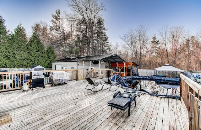 wooden terrace with a carport and a grill