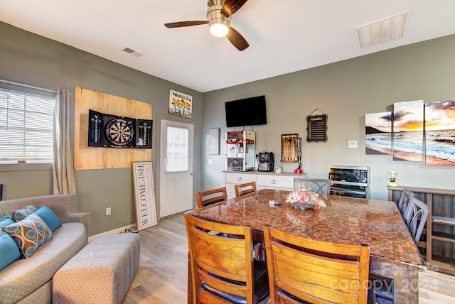 dining room with ceiling fan and light hardwood / wood-style floors