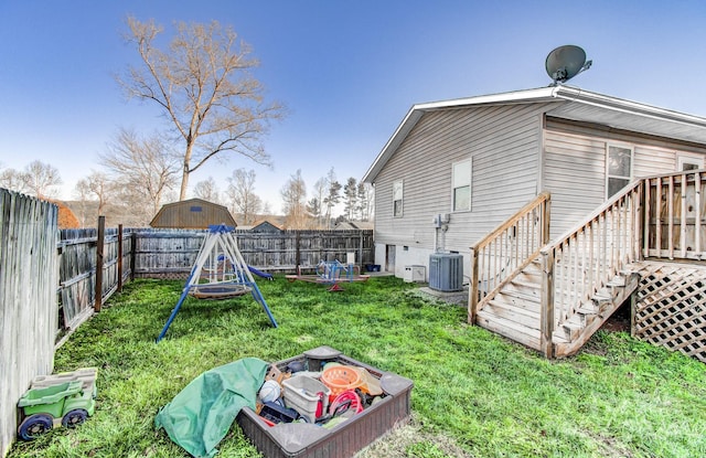 view of yard featuring a playground, central AC unit, and a deck