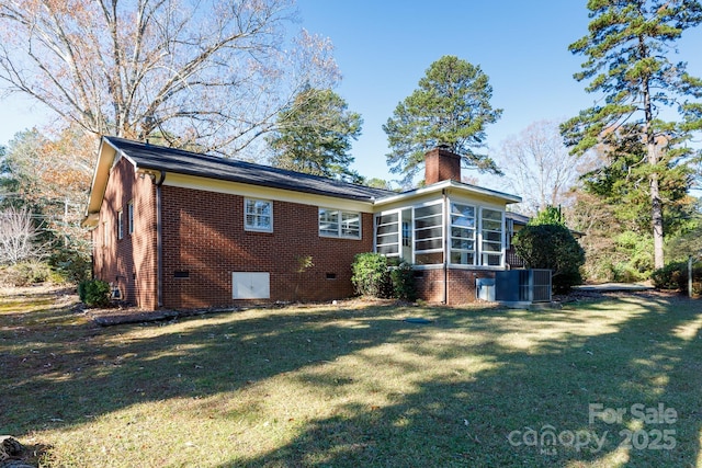 rear view of property with a sunroom, a yard, and central AC