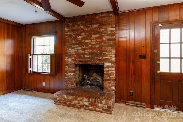 unfurnished living room featuring wooden walls and beamed ceiling