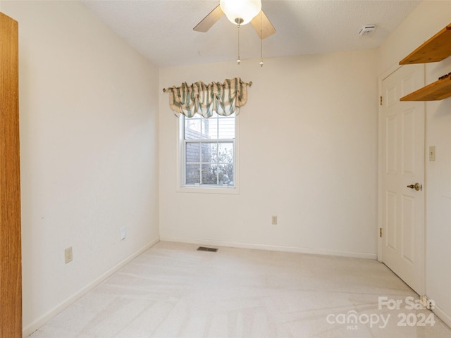 carpeted empty room featuring a textured ceiling and ceiling fan