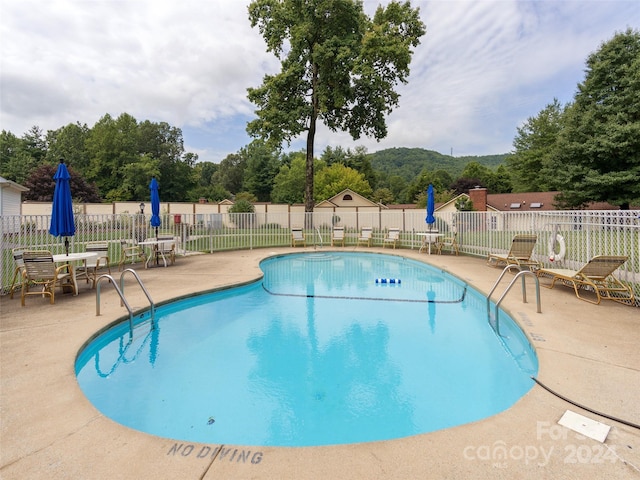 view of pool featuring a mountain view and a patio area