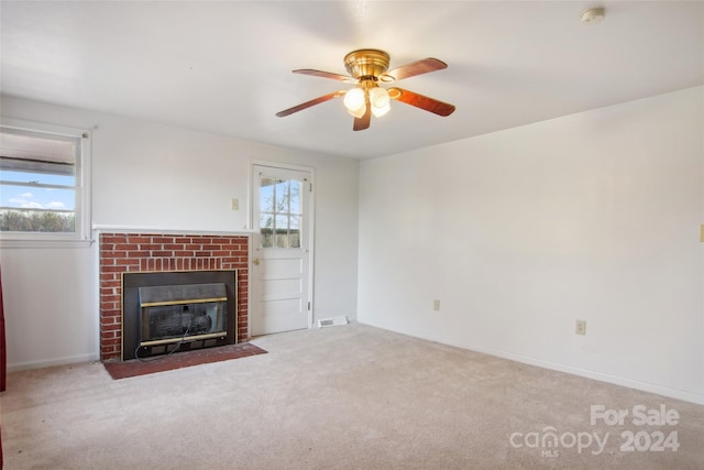 unfurnished living room featuring a fireplace, light colored carpet, and ceiling fan