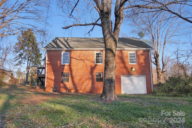 view of property exterior featuring a garage, a lawn, and a wooden deck