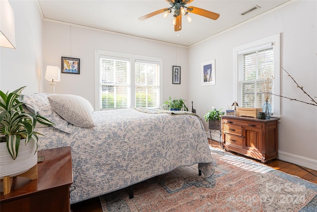 bedroom with multiple windows, ceiling fan, crown molding, and wood-type flooring