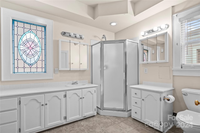 bathroom with toilet, a shower with door, vanity, and tile patterned flooring