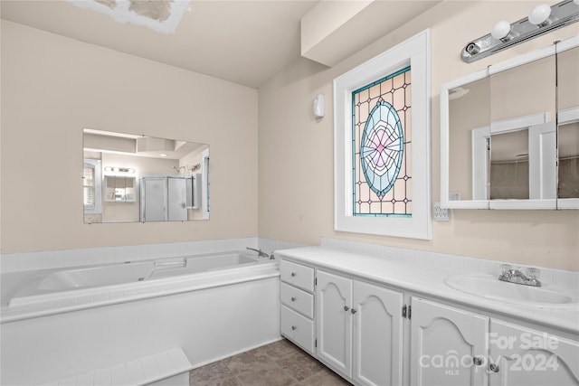 bathroom with tile patterned flooring, vanity, and separate shower and tub