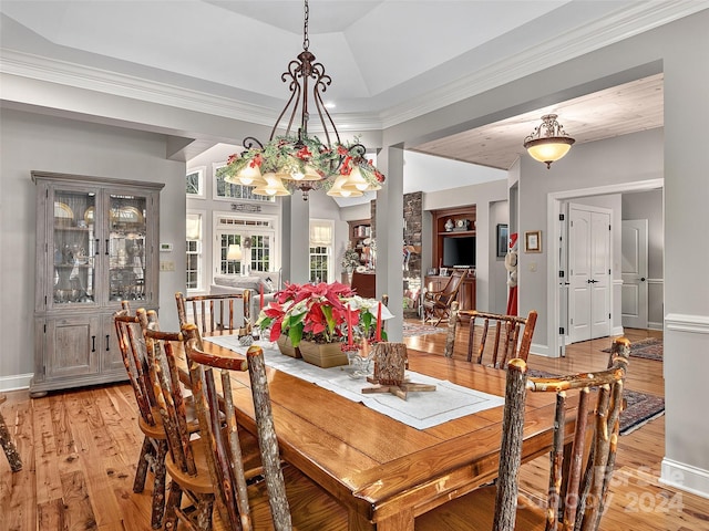 dining area with a notable chandelier, crown molding, and light hardwood / wood-style flooring