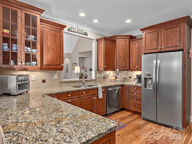 kitchen featuring decorative backsplash, light hardwood / wood-style floors, sink, and appliances with stainless steel finishes