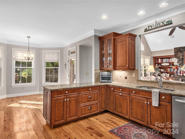 kitchen featuring sink, light stone counters, light hardwood / wood-style flooring, stainless steel dishwasher, and kitchen peninsula