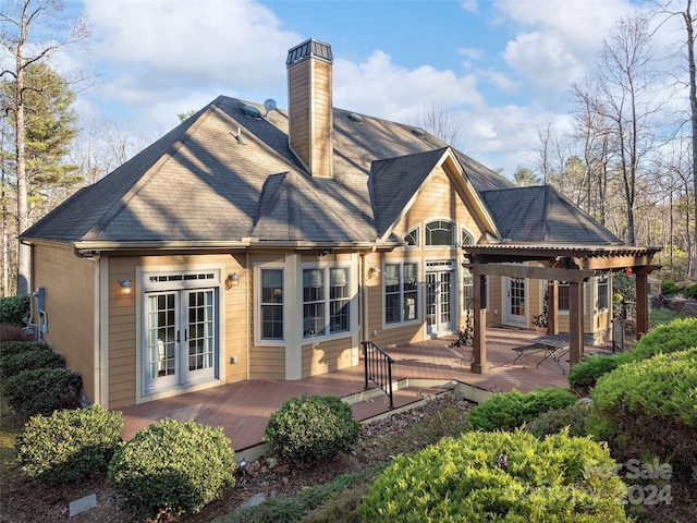 rear view of property featuring a pergola and a wooden deck