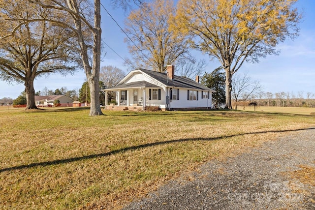 view of front of house featuring covered porch and a front yard