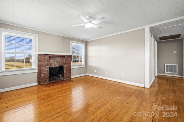 unfurnished living room with a fireplace, ceiling fan, crown molding, and wood-type flooring