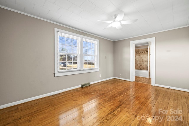 empty room featuring hardwood / wood-style floors, ceiling fan, and ornamental molding