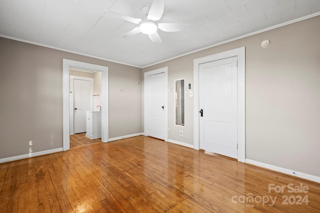 unfurnished bedroom featuring wood-type flooring, ensuite bath, ceiling fan, and crown molding