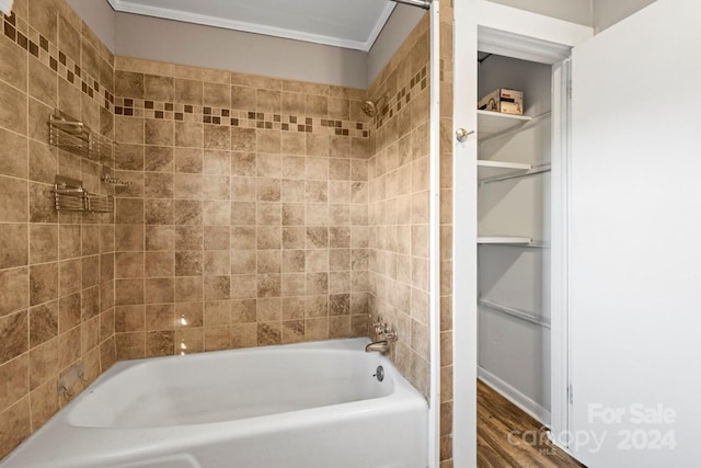 bathroom featuring crown molding, tiled shower / bath, and hardwood / wood-style flooring