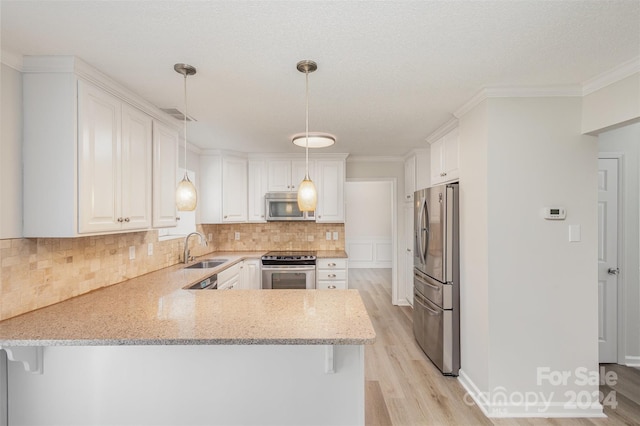 kitchen with white cabinetry, kitchen peninsula, and appliances with stainless steel finishes