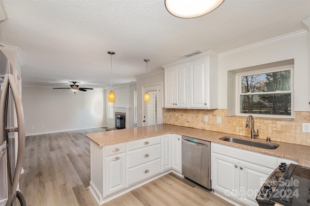 kitchen featuring white cabinets, sink, light wood-type flooring, appliances with stainless steel finishes, and kitchen peninsula