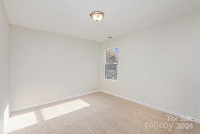 unfurnished room featuring light carpet