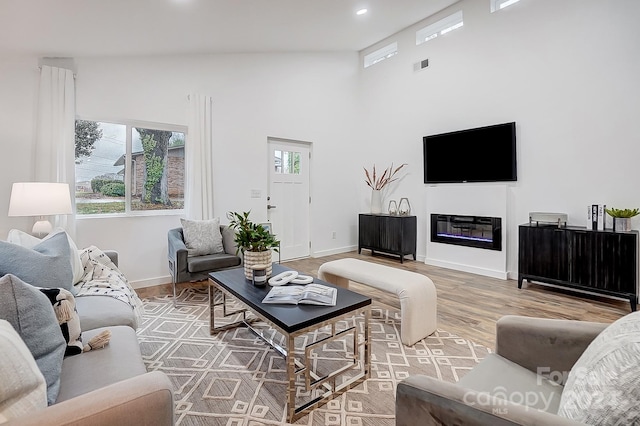 living room featuring wood-type flooring and high vaulted ceiling