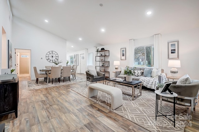 living room featuring light wood-type flooring and high vaulted ceiling