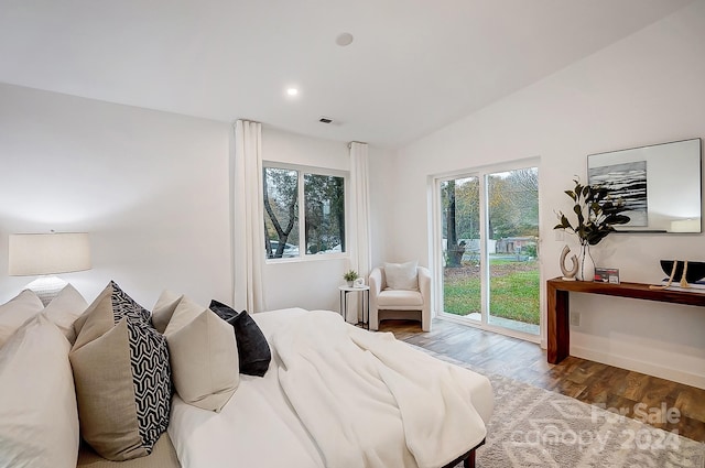 bedroom with hardwood / wood-style floors, access to exterior, and lofted ceiling