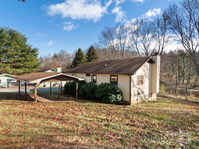 view of home's exterior with a yard and a carport