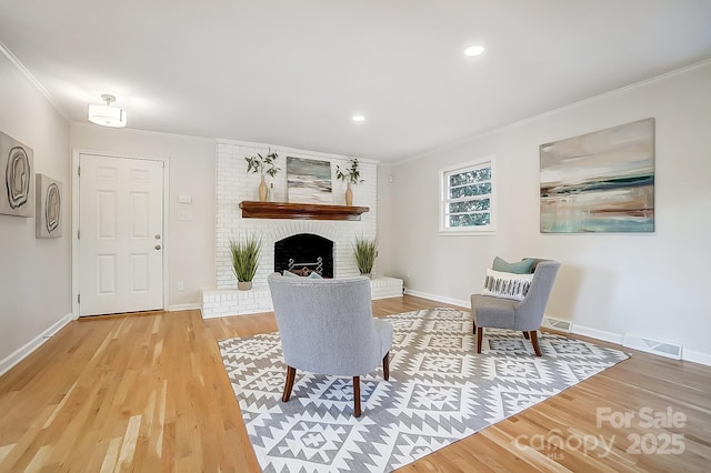 living room featuring hardwood / wood-style flooring, a fireplace, and ornamental molding