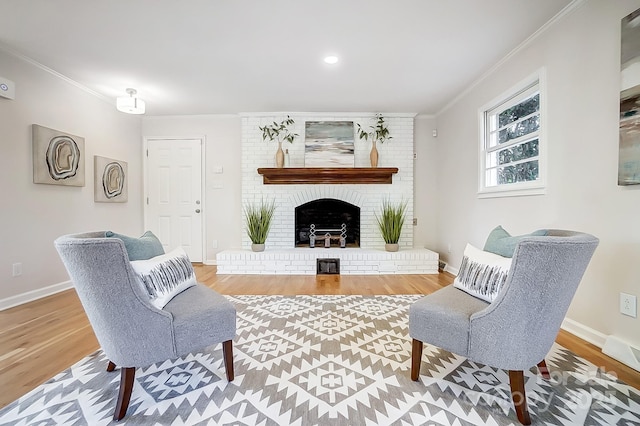 living room with crown molding, wood-type flooring, and a brick fireplace