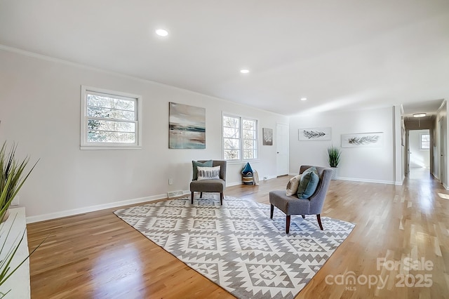 sitting room featuring ornamental molding, a healthy amount of sunlight, and hardwood / wood-style flooring