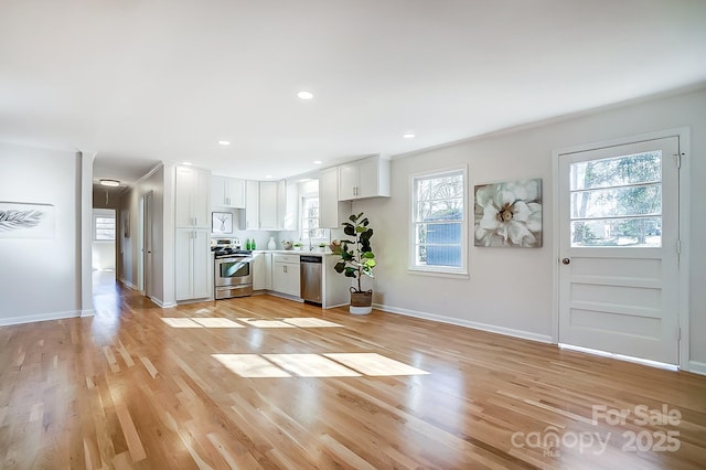 kitchen featuring sink, white cabinets, light wood-type flooring, and appliances with stainless steel finishes