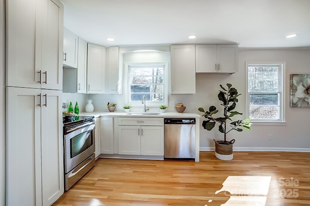 kitchen with sink, white cabinets, a healthy amount of sunlight, and appliances with stainless steel finishes