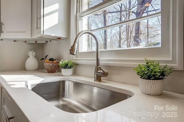 room details with light stone countertops and sink