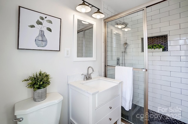 bathroom featuring vanity, toilet, and a shower with door