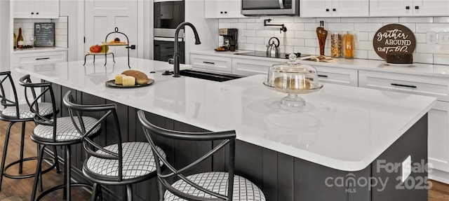 kitchen with a large island, sink, and white cabinets