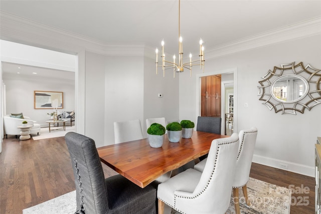 dining area featuring dark wood-style floors, a chandelier, ornamental molding, and baseboards