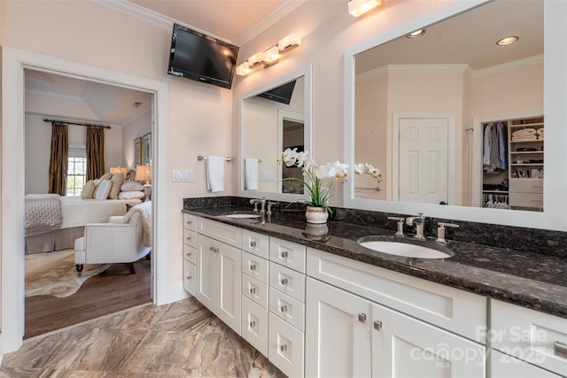 bathroom featuring ensuite bathroom, double vanity, a sink, and crown molding