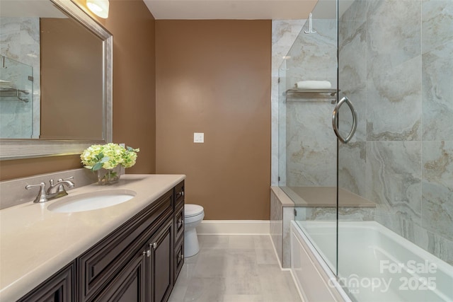 full bath with combined bath / shower with glass door, toilet, vanity, and baseboards