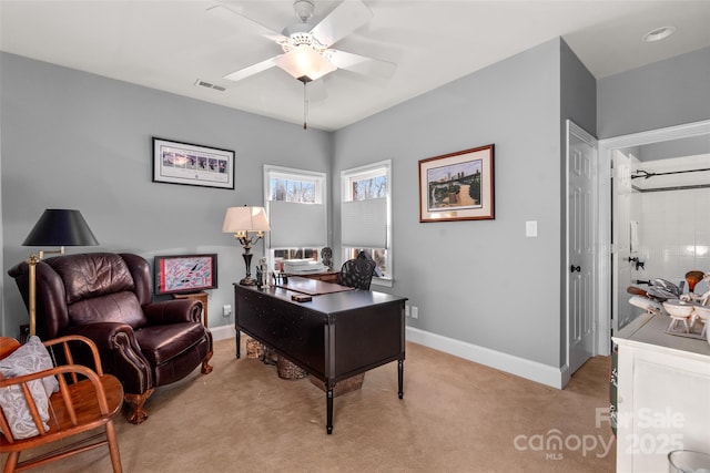 home office featuring baseboards, ceiling fan, visible vents, and light colored carpet