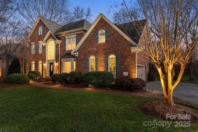 view of front of property with driveway, brick siding, and a front lawn