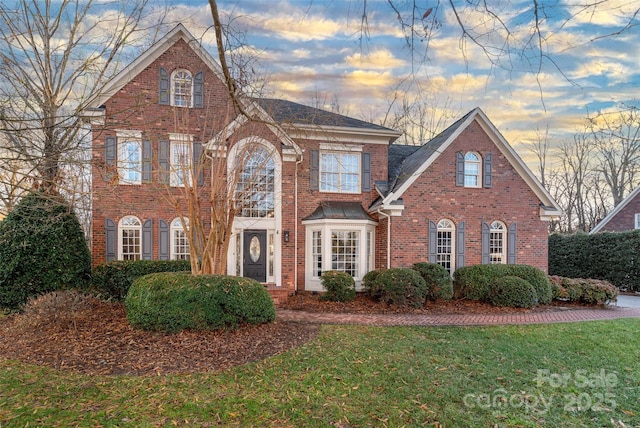 view of front facade featuring brick siding and a front lawn