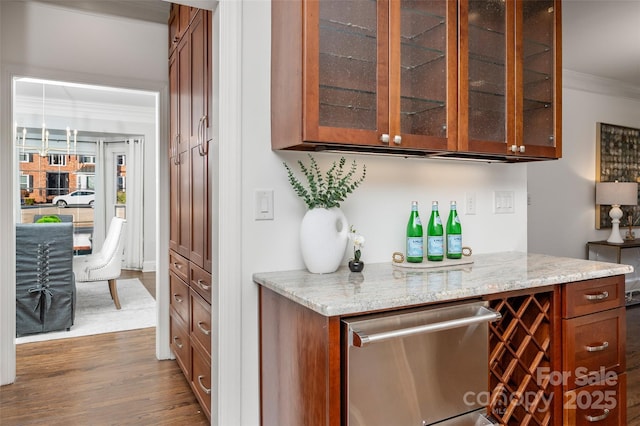 bar featuring dark wood-style flooring, crown molding, a dry bar, and dishwasher