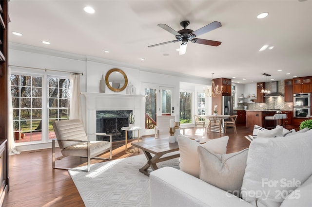 living room with a high end fireplace, plenty of natural light, recessed lighting, and wood finished floors