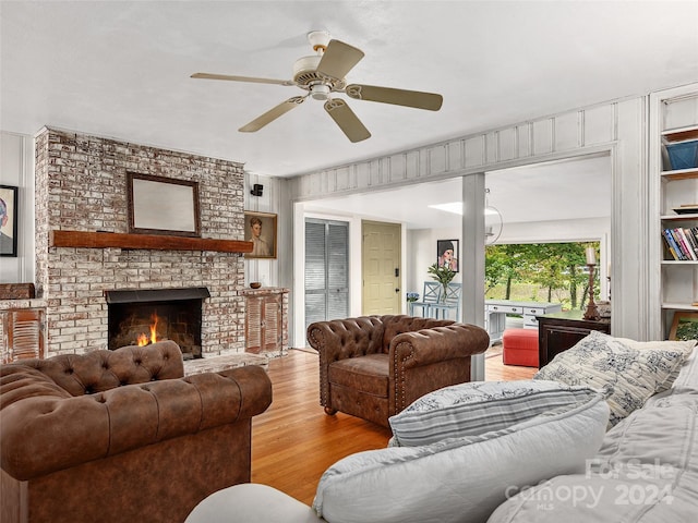 living room featuring ceiling fan, a fireplace, and light hardwood / wood-style floors