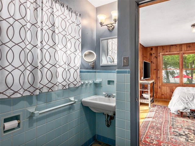 bathroom featuring sink and wooden walls