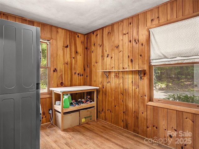 interior space featuring wooden walls, washer / clothes dryer, and light wood-type flooring